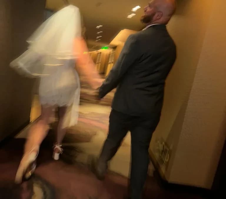 Newlyweds running joyfully across wedding venue lawn