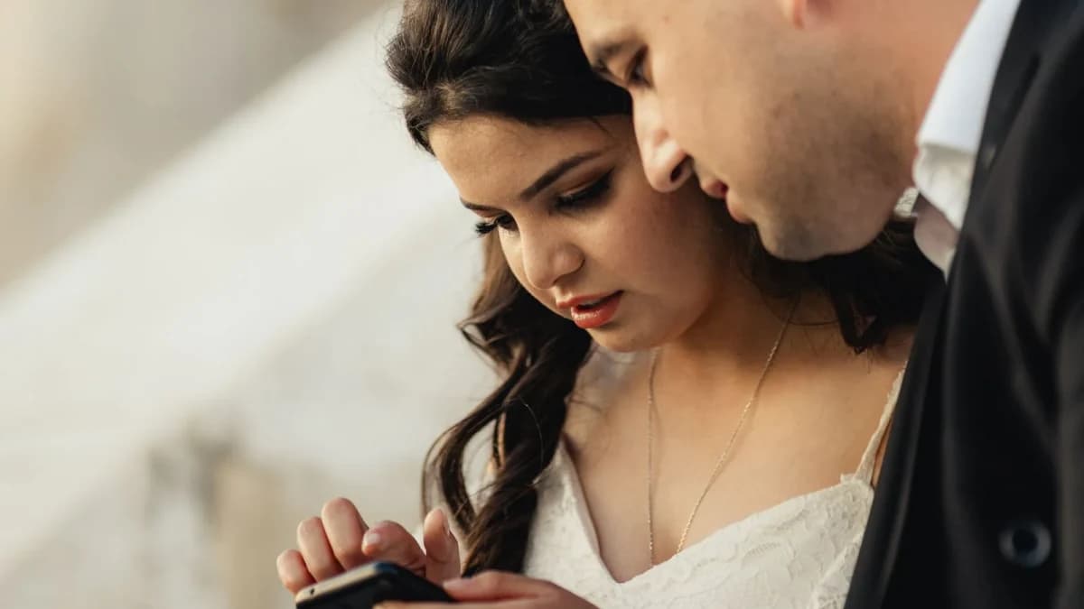 Newlyweds viewing wedding photos together on a phone