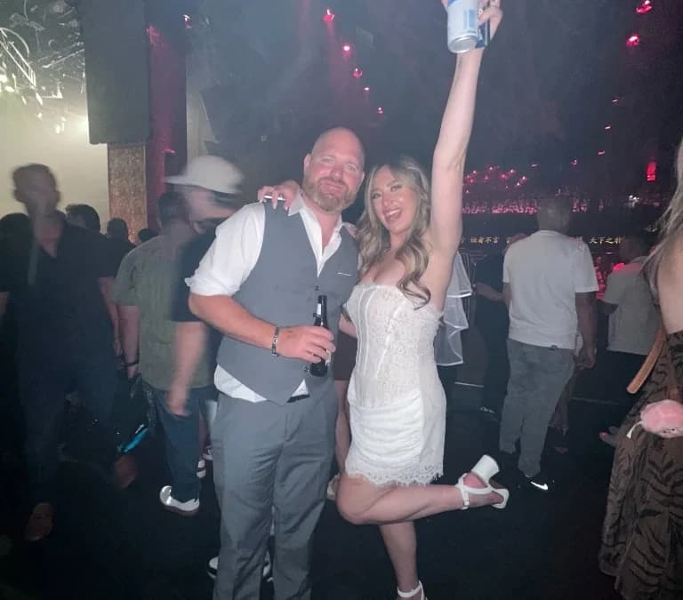 Newlyweds dancing surrounded by guests taking photos on phones