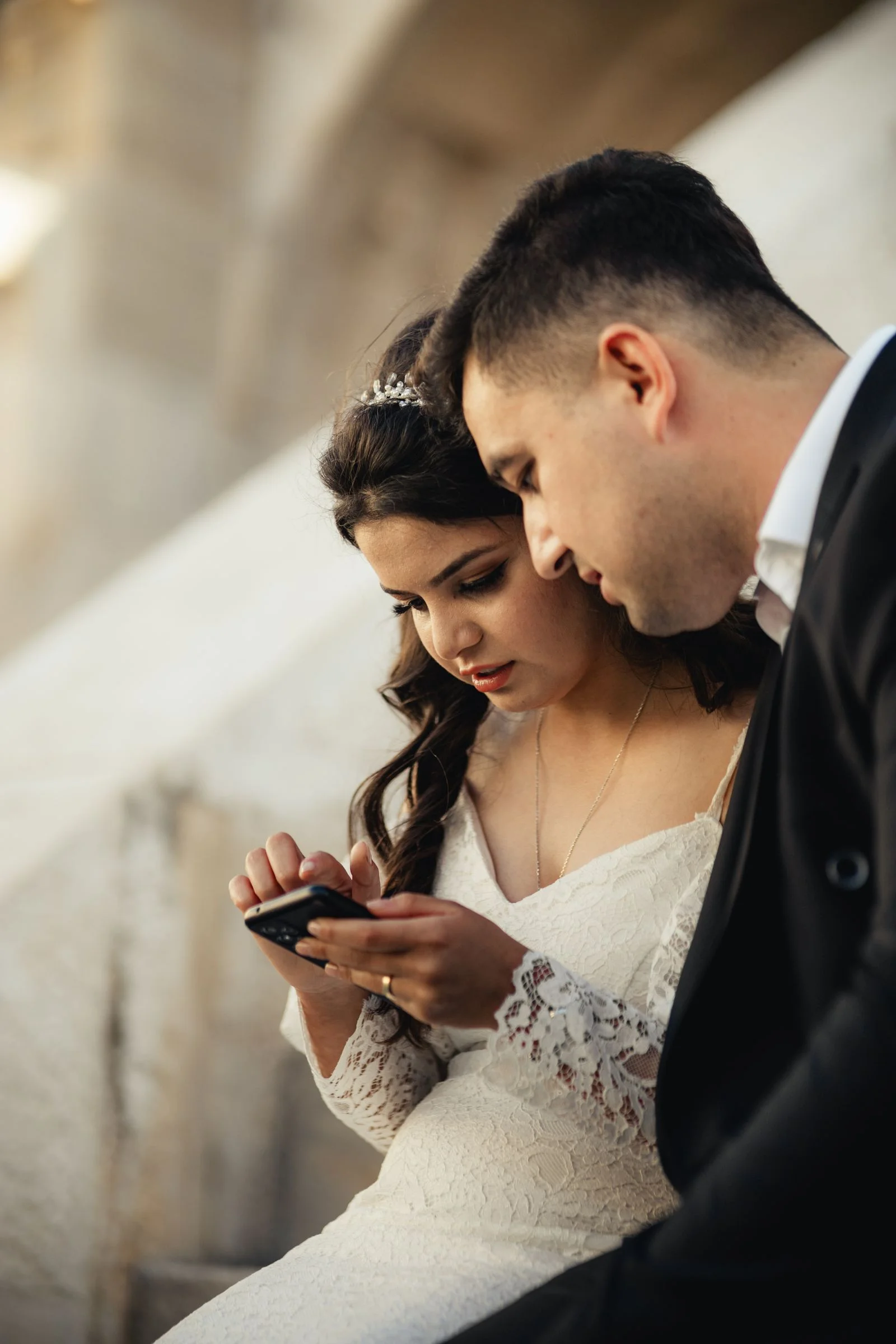 Bride and groom looking at wedding photos together on a smartphone