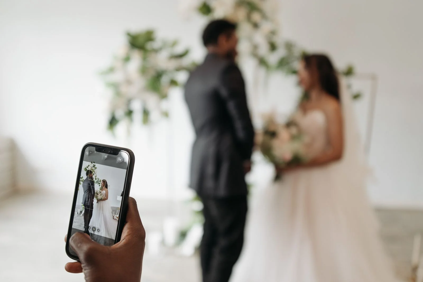 Wedding guest using a smartphone to photograph the couple