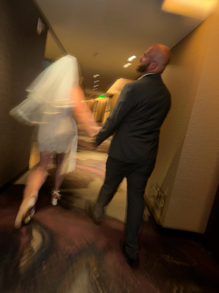 Couple running through wedding venue